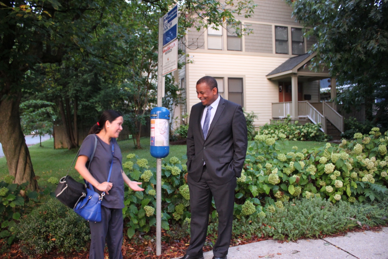 Photo of Secretary Foxx waiting at bus stop with Lan