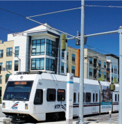 California Light rail vehicle traveling with development behind  