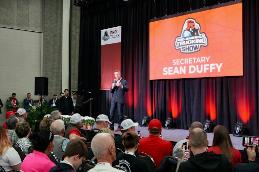 Secretary Duffy on stage speaking to an audience at MATS