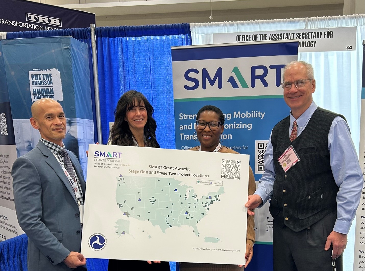 From left to right: Thy Nguyen (SMART Team Lead), Raine Pike, Alfreda Johnson, and Stan Caldwell (SMART Director) holding a poster of SMART Grant Award project locations at the Transportation Research Board (TRB) Annual Meeting.