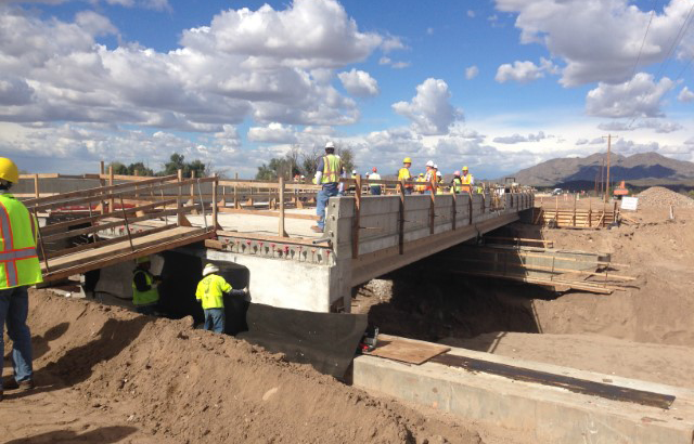 Construction workers work on building the Gila River Bridge.