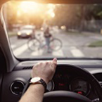 Driver point of view, stopping for a person walking a bike across a road at a crosswalk.