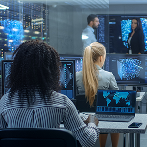 A group of people in a room looking at computer screens filled with data.