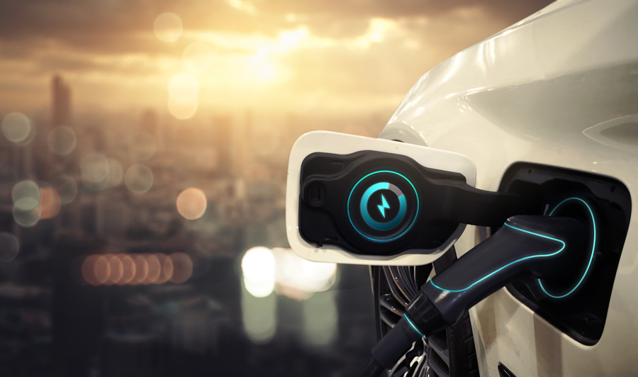 The front of an electric vehicle with a charger plugger in.