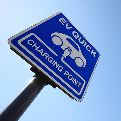 A road sign advertising an EV quick charging point.