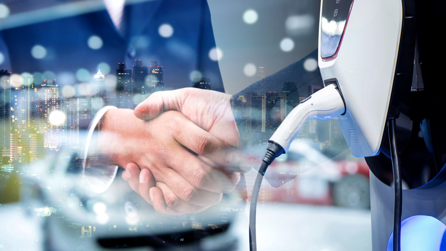 Collage with overlaid images of an EV charger, a nighttime city skyline, and two hands in a handshake 
