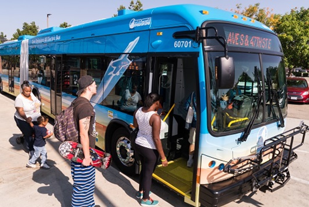 People board an electric bus.