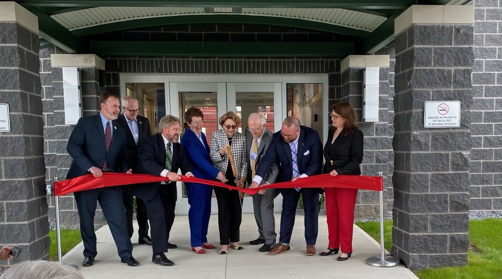 Group of people prepare to cut ribbon for grand opening of New Seaway Visitor Center