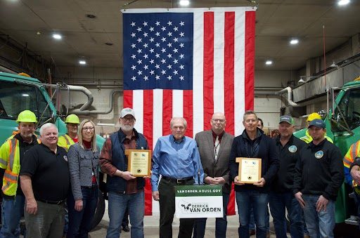 Secretary Duffy and Congressman Van Orden standing with Monroe County officials presented with plaques