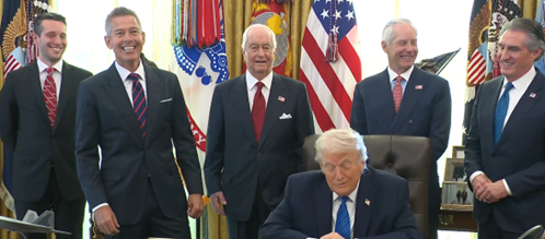 Secretary Duffy standing with other Cabinet officials behind President Trump