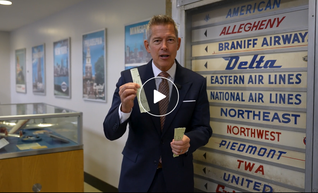 Secretary Duffy holding paper flight strips