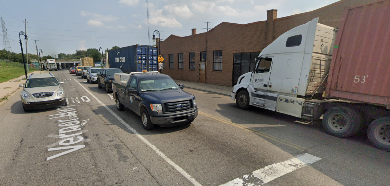Streetview image of cars and large trucks on roadway.