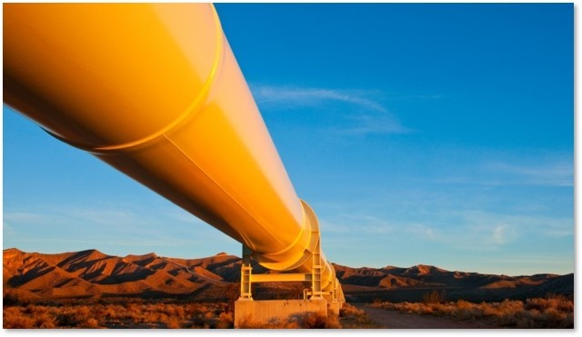 Yellow pipeline across a desert landscape with a mountain backdrop