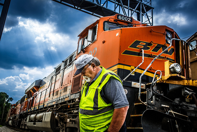 Photo of a freight train and worker in a rail yard