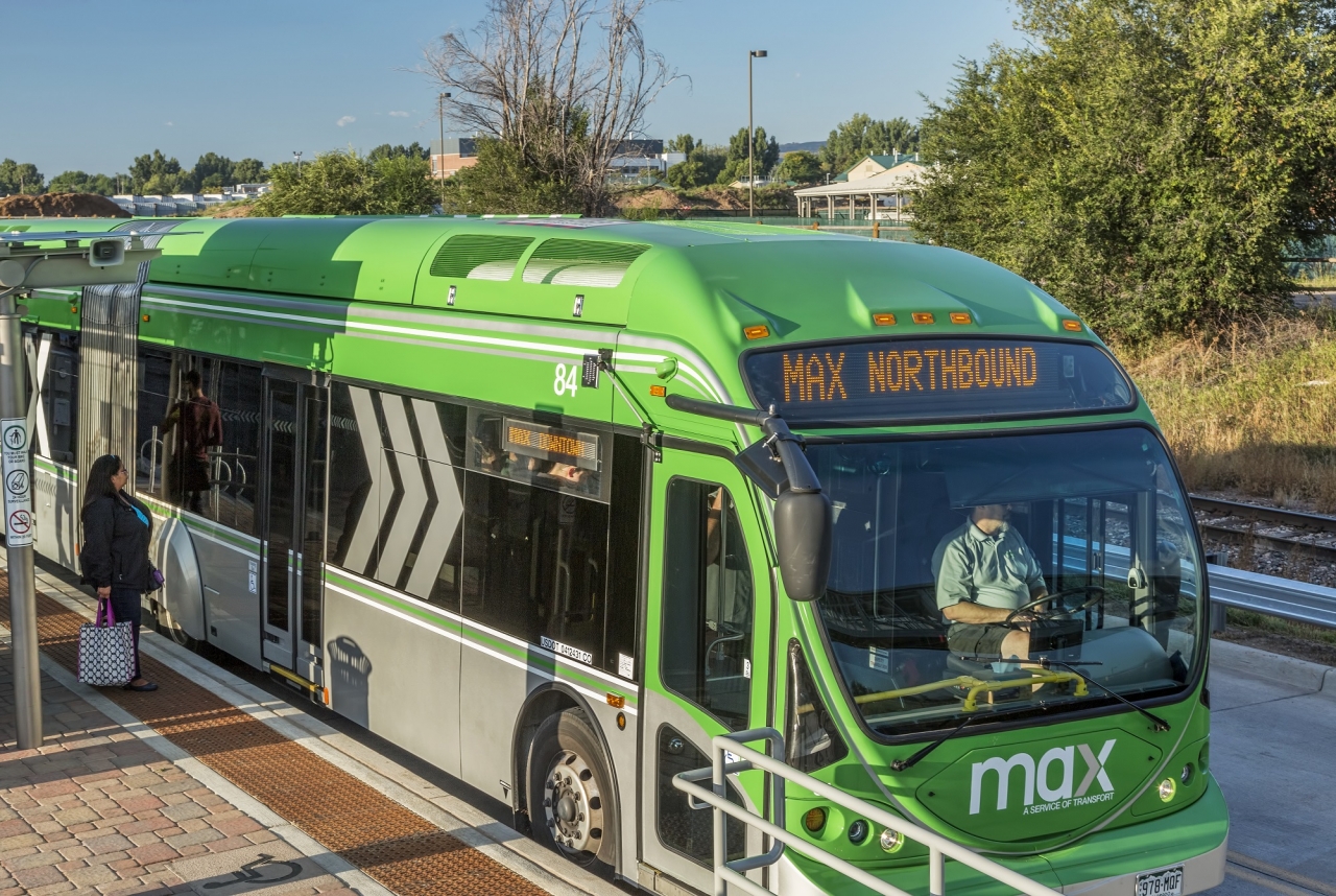 Photo of a commuter bus picking up a passenger at a bus stop
