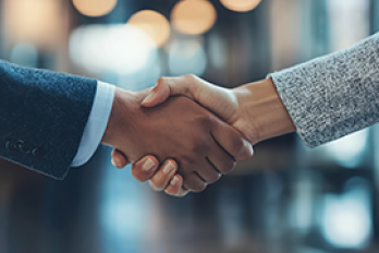 Two people shake hands.