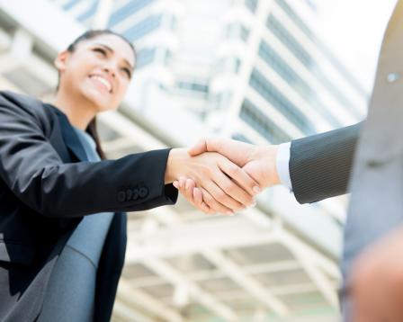 A man and woman shake hands.