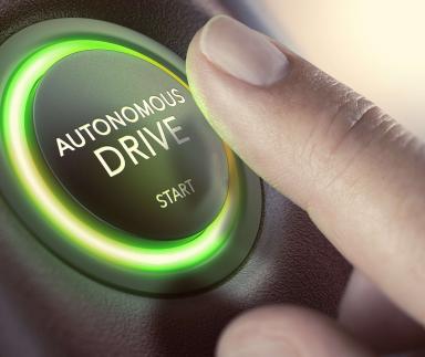 A finger pushes an autonomous start button.
