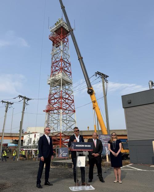 Secretary Duffy speaking at press conference behind ATC radar tower