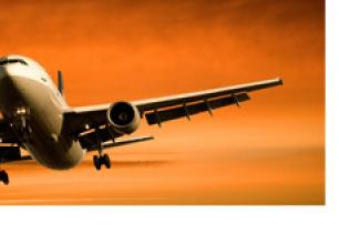Airplane flyinf through a sunset-lit sky