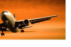 Airplane flyinf through a sunset-lit sky